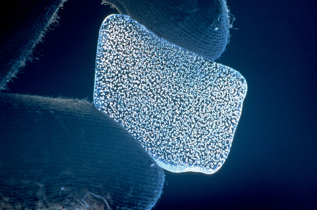 רסיס של קרח מאנטארקטיקה חושף את שלל בועות האוויר הקטנות שכלואות בתוכו. מקור התמונה: File:CSIRO ScienceImage 521 Bubbles in Ice.jpg - Wikimedia Commons