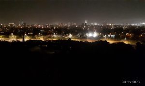 תל אביב בלילה. החלק החשוך - הגן הבוטני שבמוזיאון הטבע, במרכז (מואר) נתיבי האיילון ומעל העיר - הילה של זיהום אור